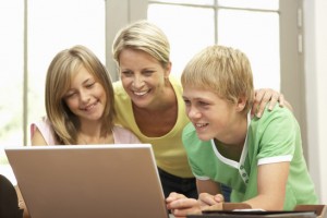 Mother And Teenage Children Using Laptop At Home Mother And Teenage Children Using Laptop At Home